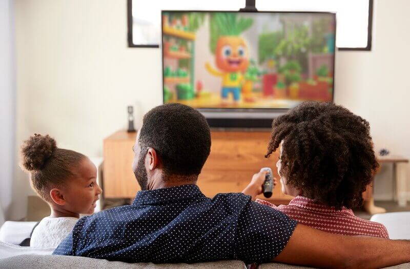 A family is watching cartoons on the tv in the living room